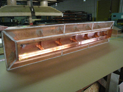 A custom copper roof vent on the shop bench